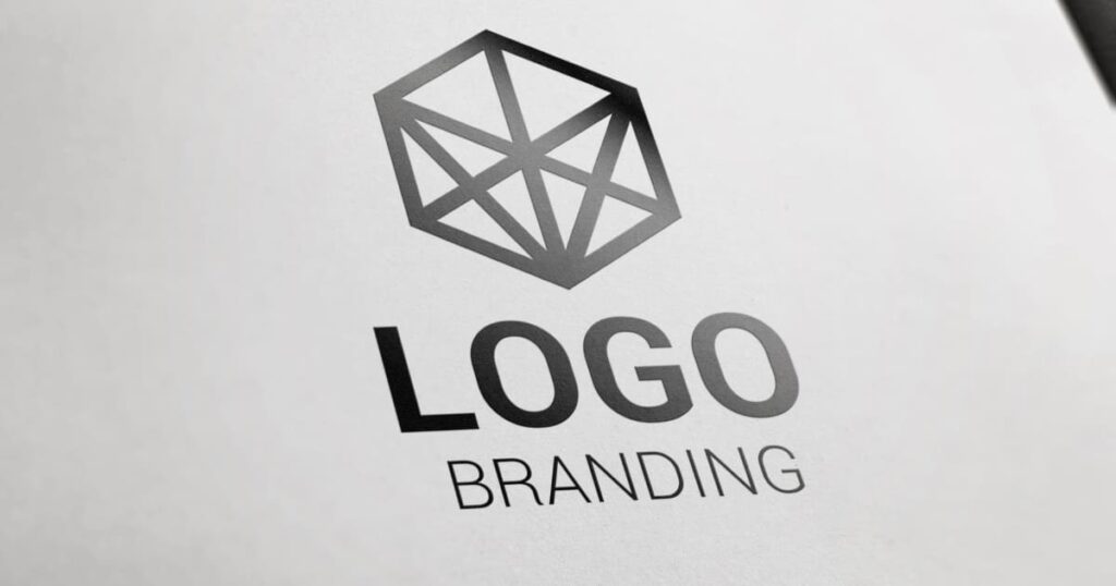Logotipo geométrico en blanco y negro sobre papel con la palabra branding destacada