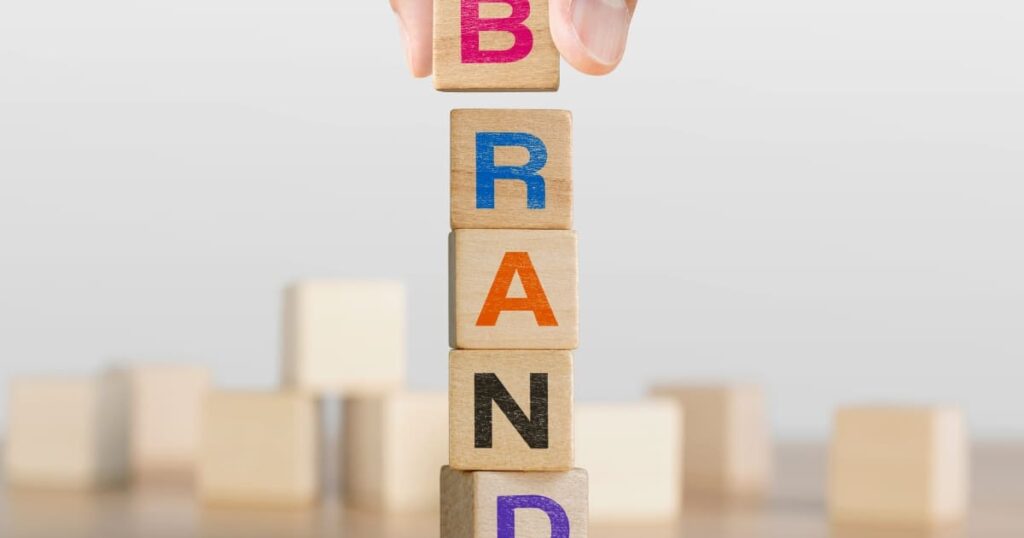 Bloques de madera formando la palabra BRAND como representación visual del concepto de marca y recordación.